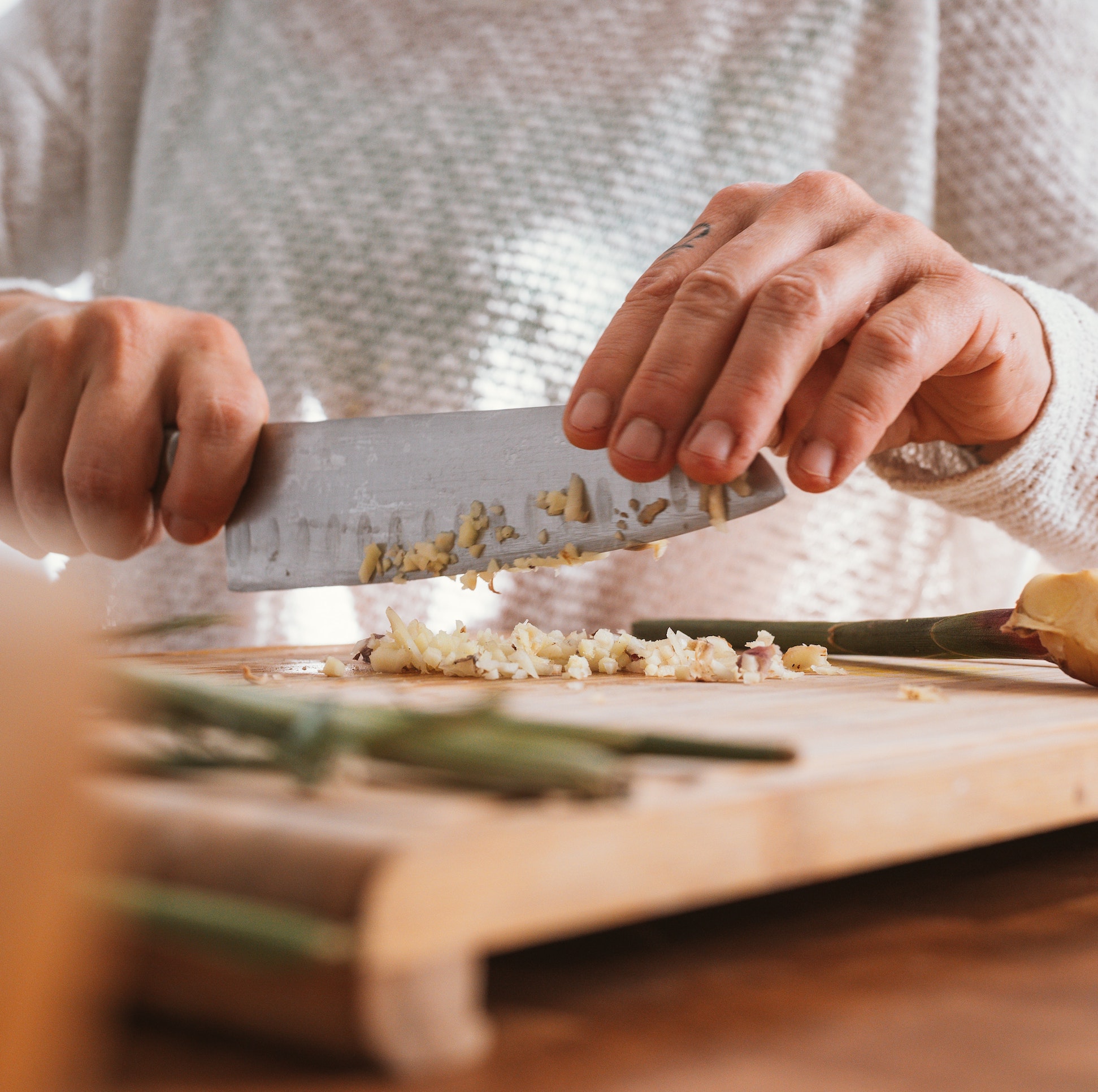 Person taking a private in-home cooking class learning to chop vegetables
