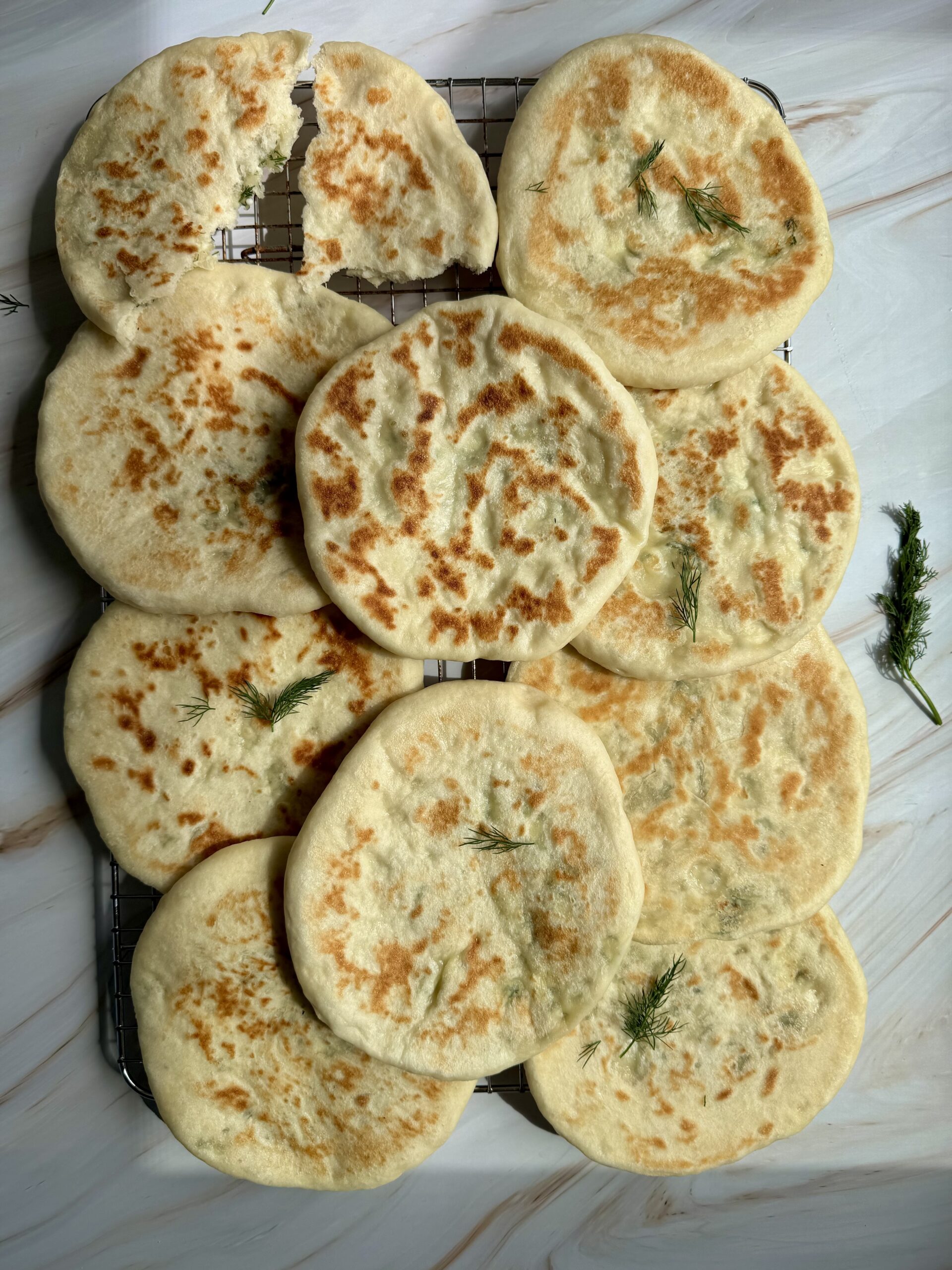 wire rack with cooked greek pitas.