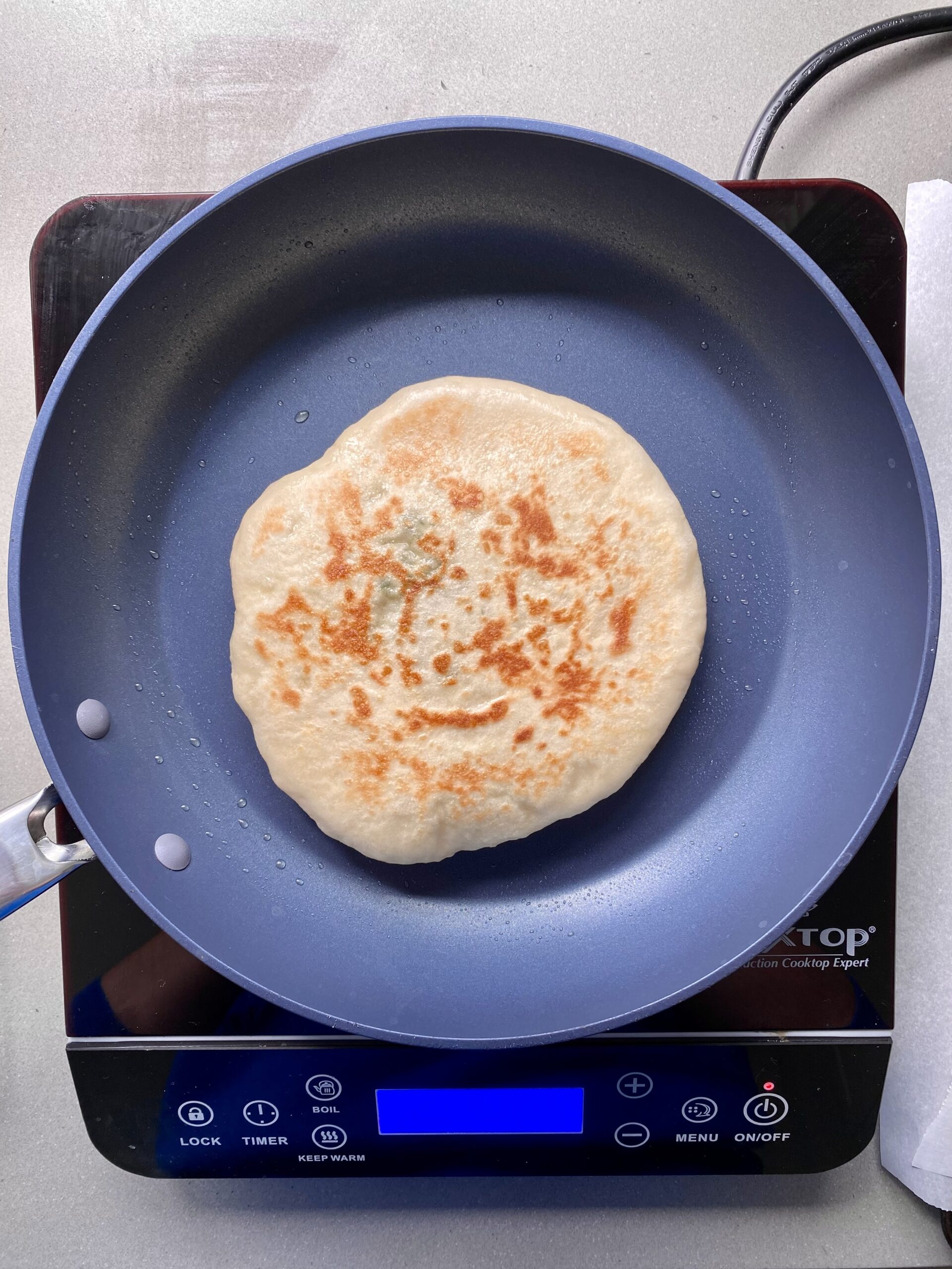 golden brown pita on a pan cooking.