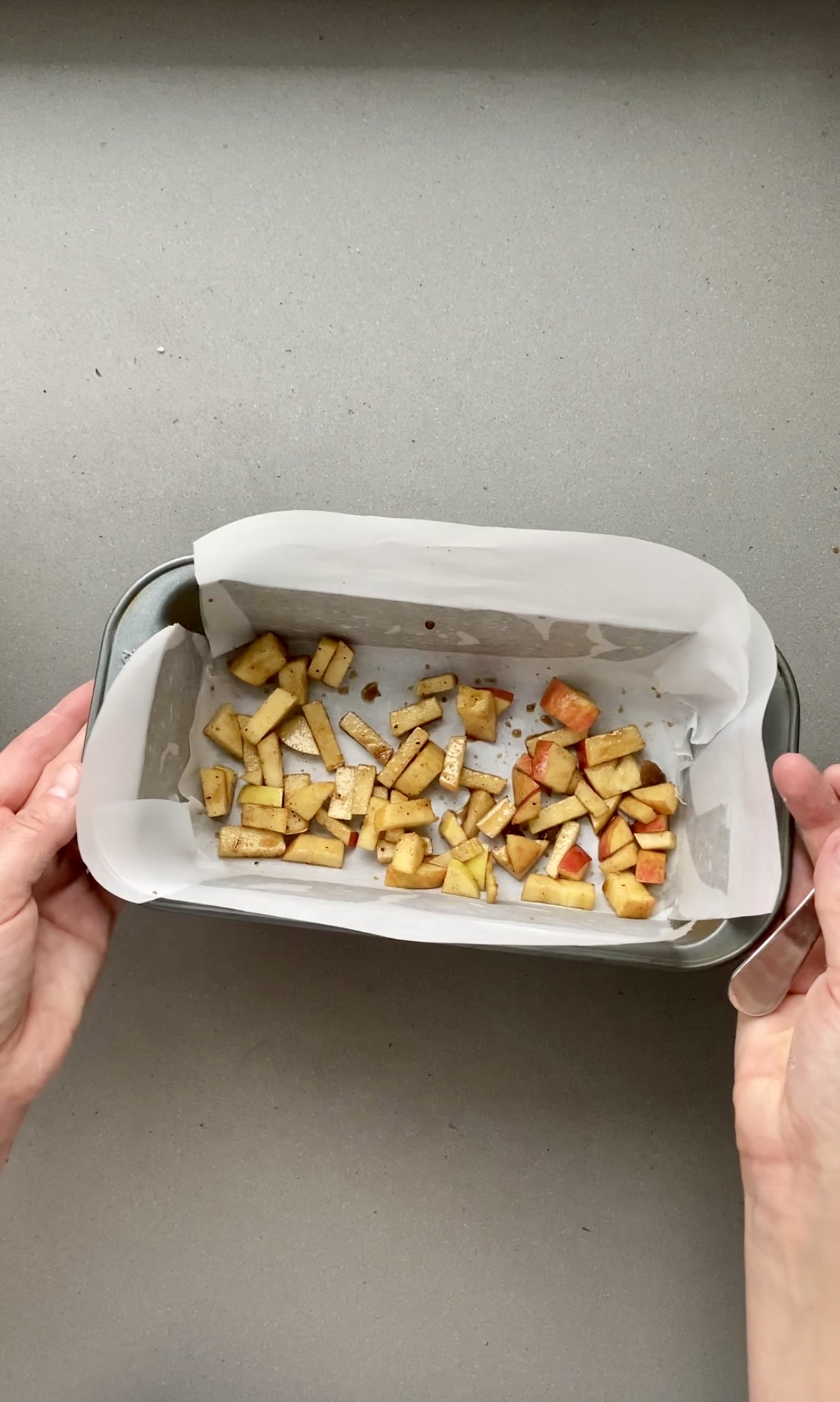 small amount of diced apples and pears added to a parchment paper lined loaf pan.
