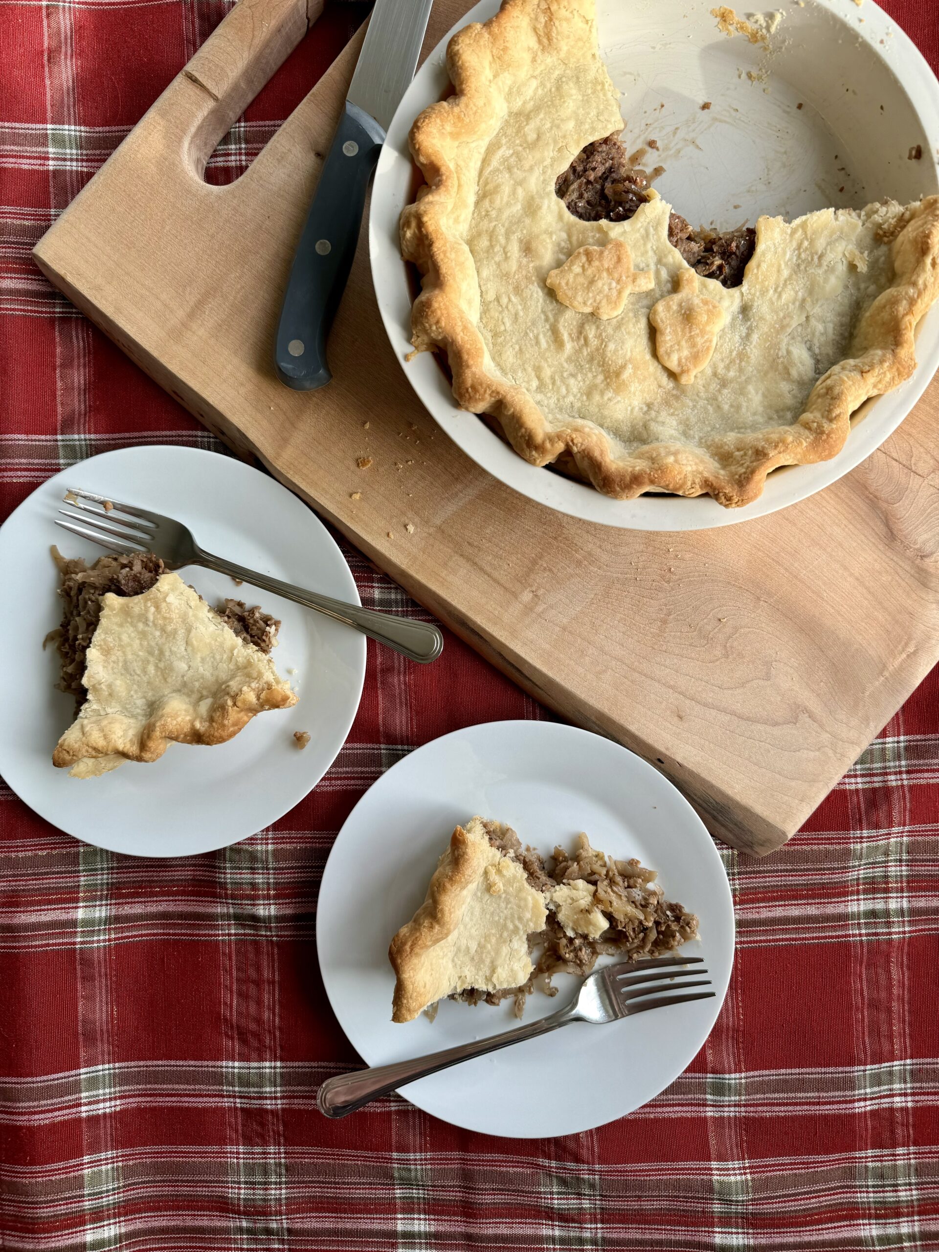 vegan meat pie cut and served on two white plates.