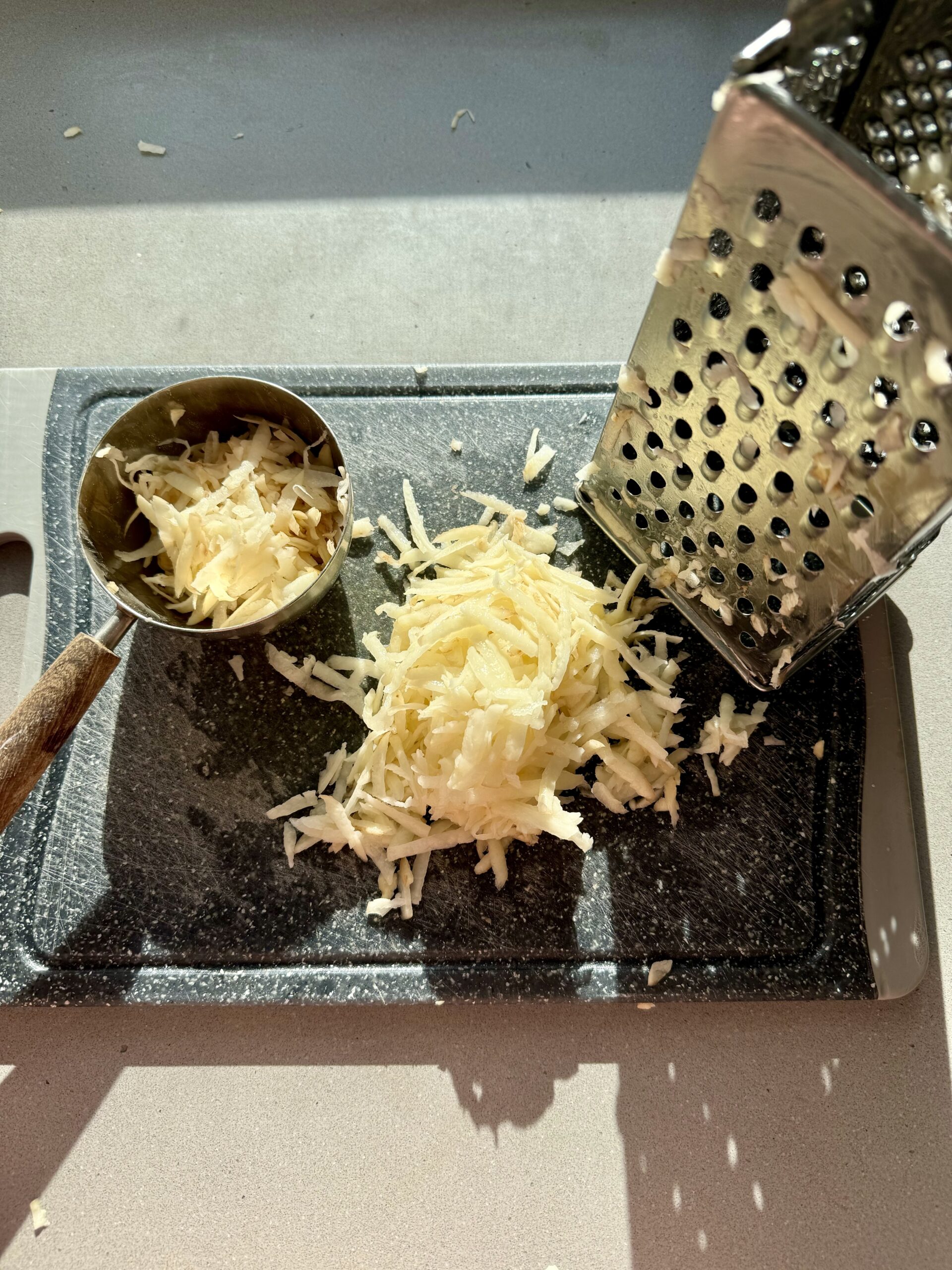 shredded potato on a cutting board.