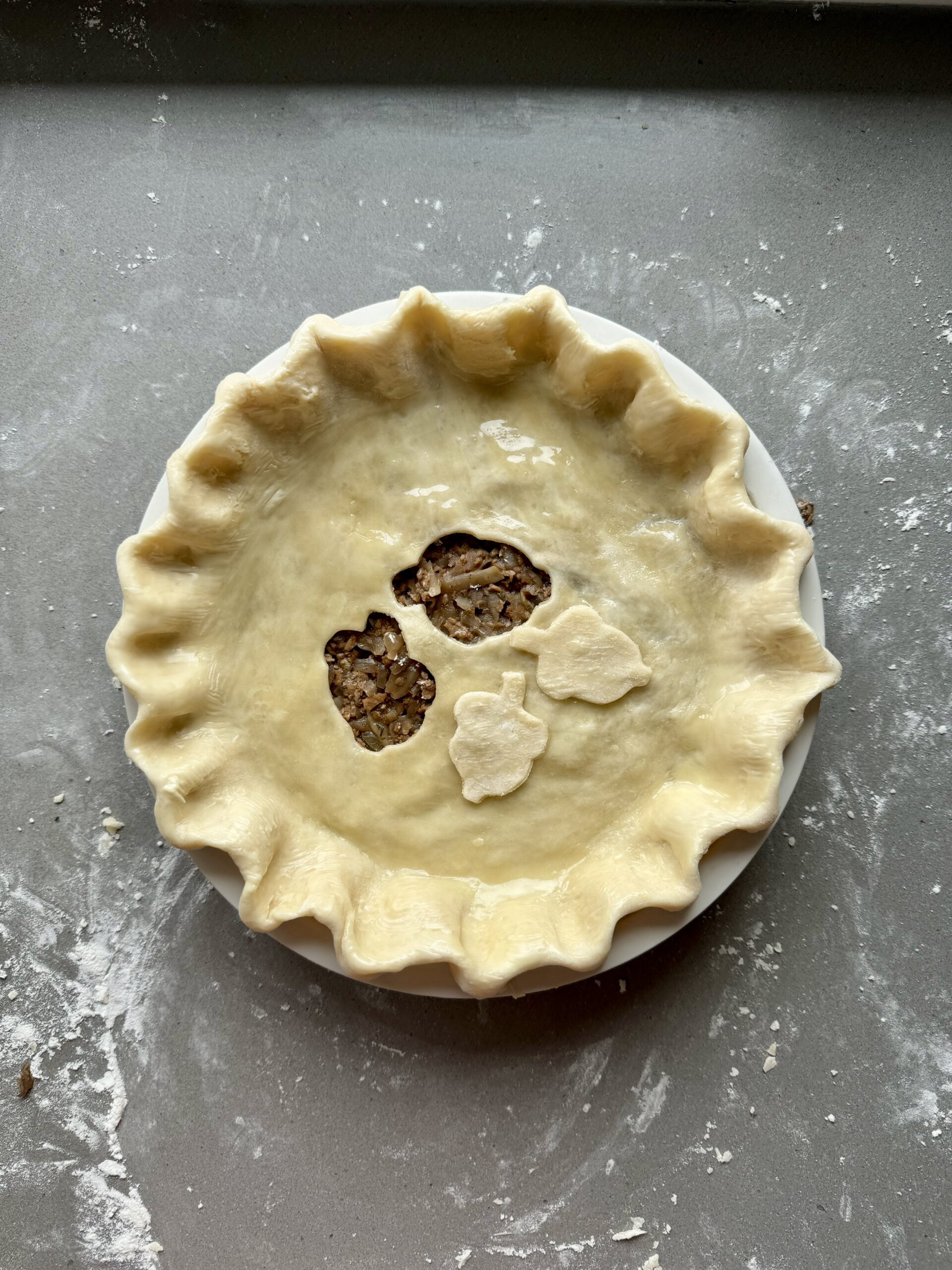 vegan meat pie brushed with milk and ready for baking.