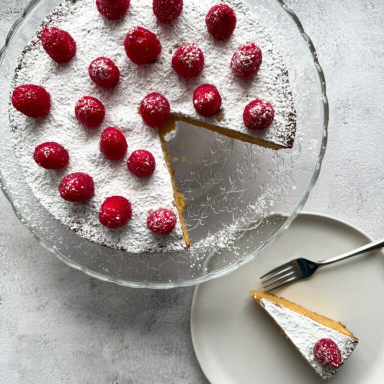 almond cake with fresh raspberries on top.