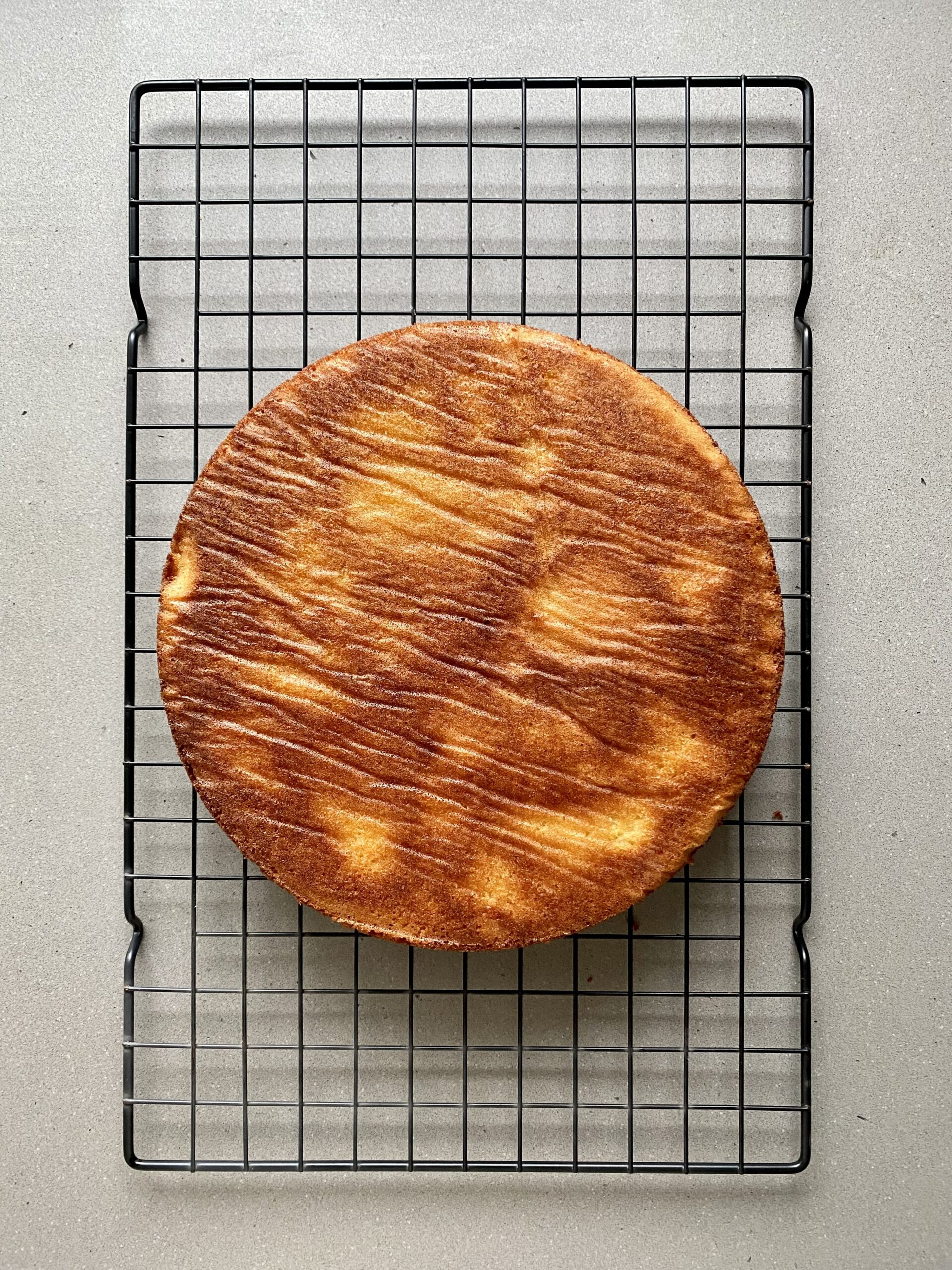 almond raspberry cake on a wire rack after it's been baked.