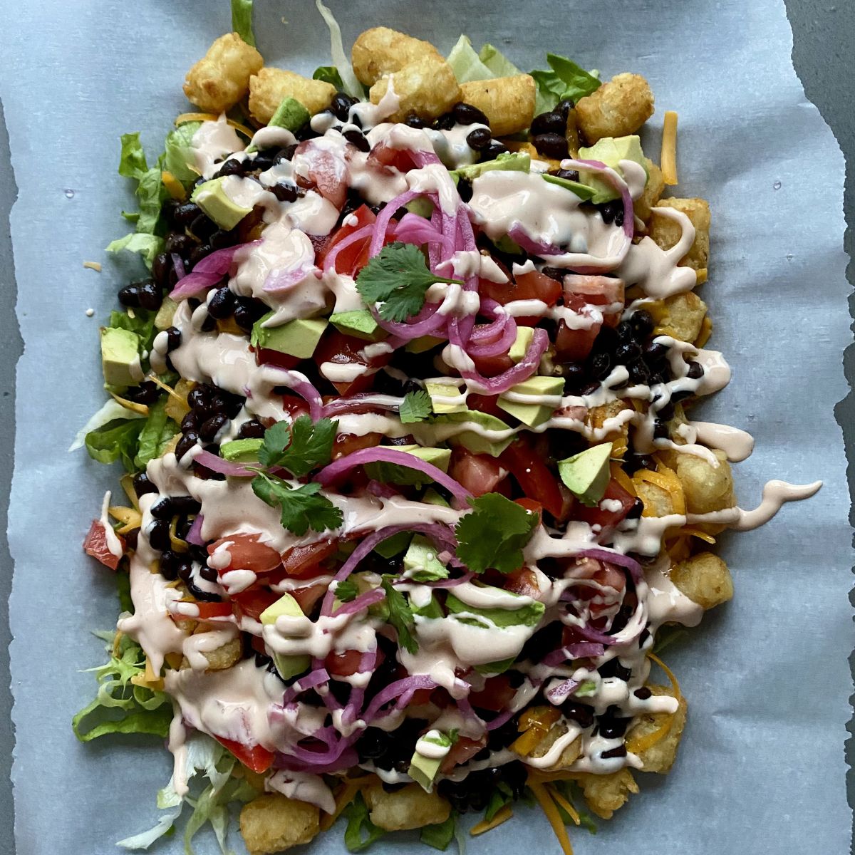 Loaded tater tot casserole on a baking sheet.