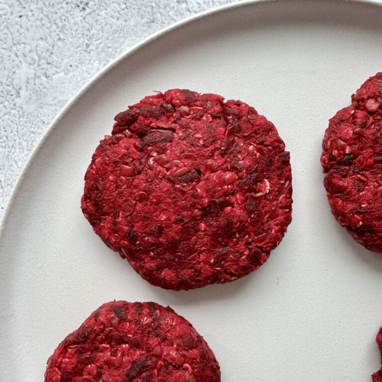 beet and lentil burger patties on a white plate.