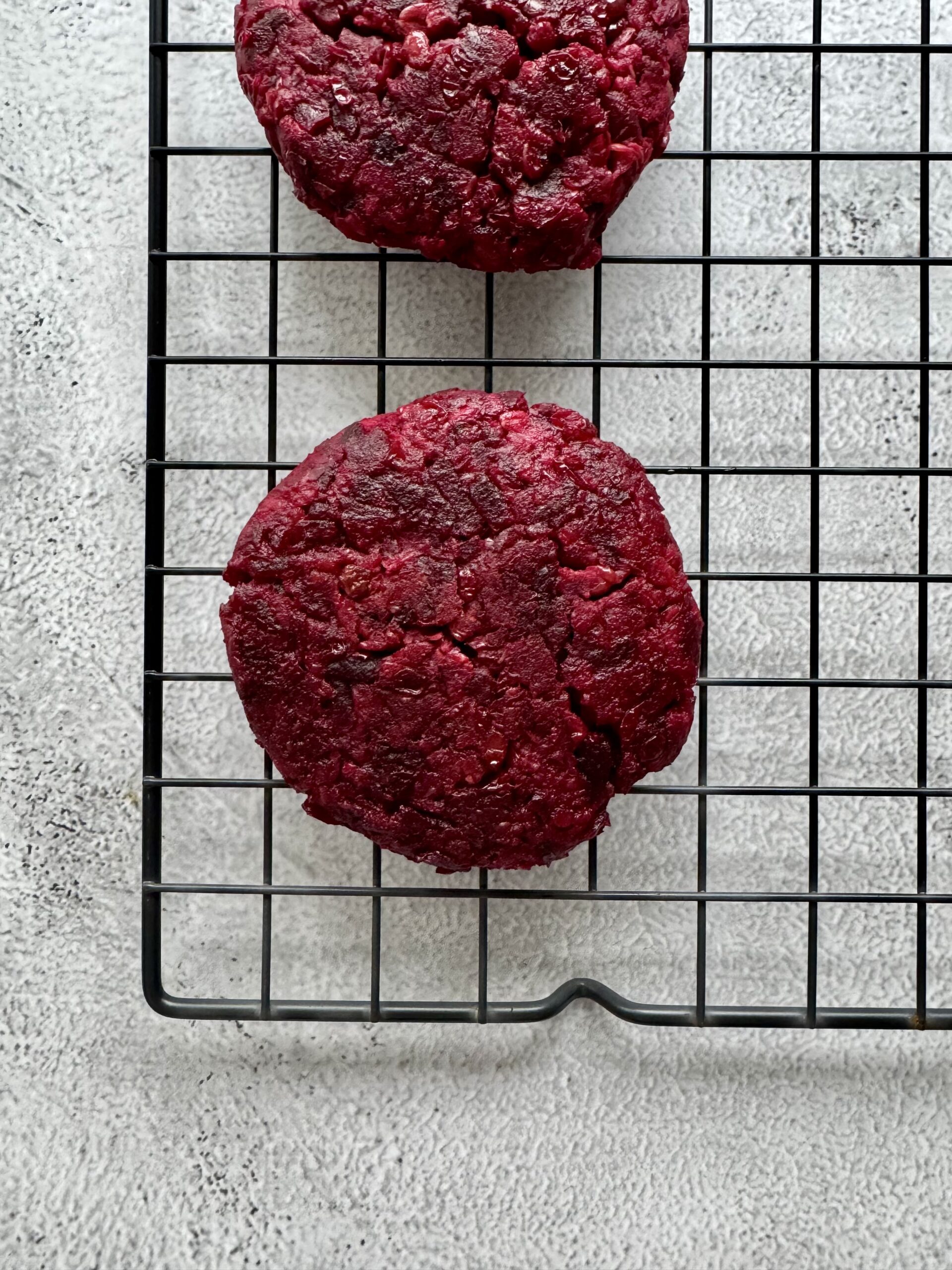 cooked beet burgers on a wire rack.