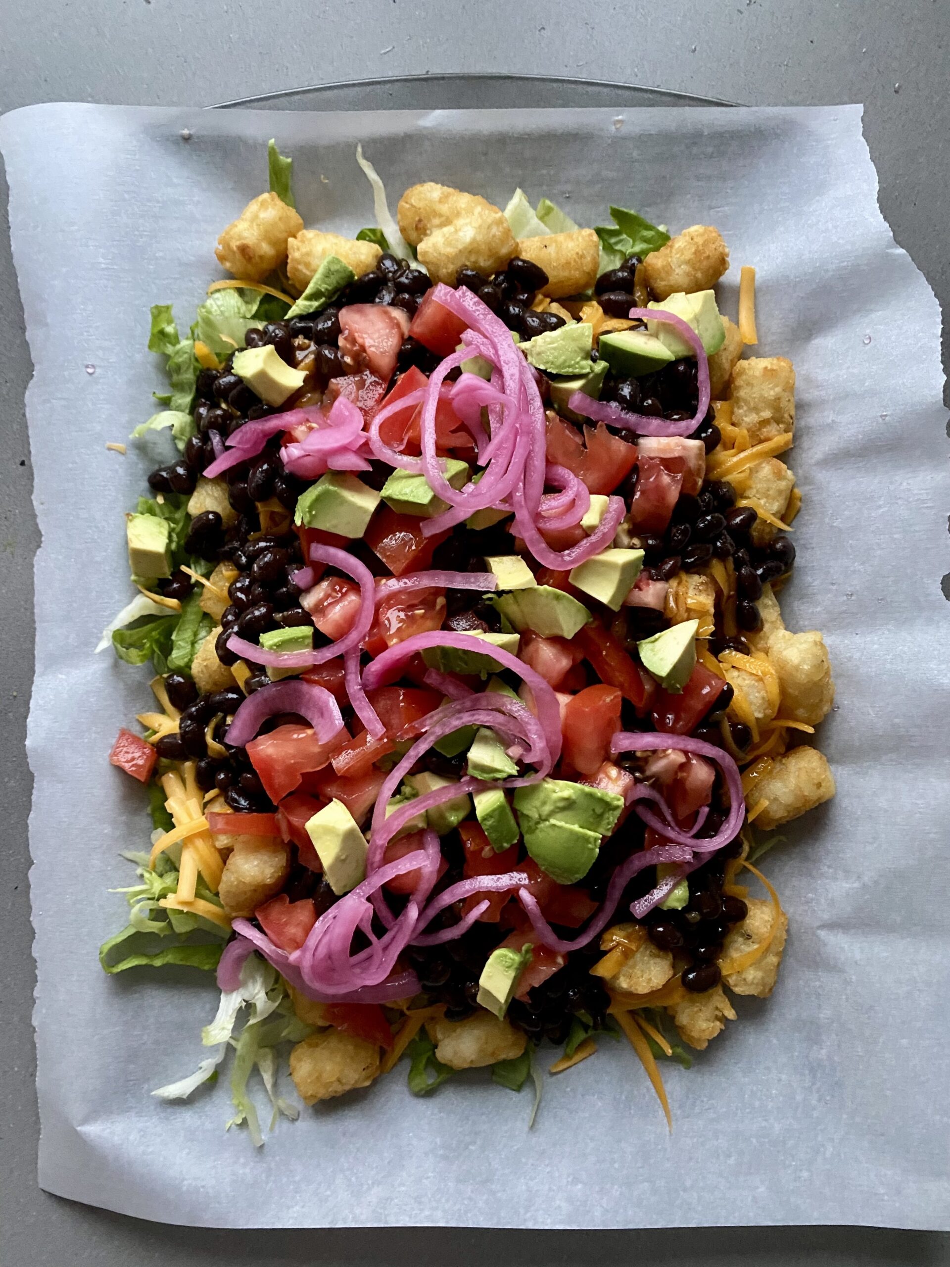 tomatoes, avocado and pickled onions added on top of the black beans.
