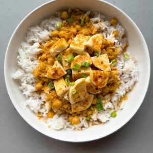 butter halloumi curry on rice in a bowl