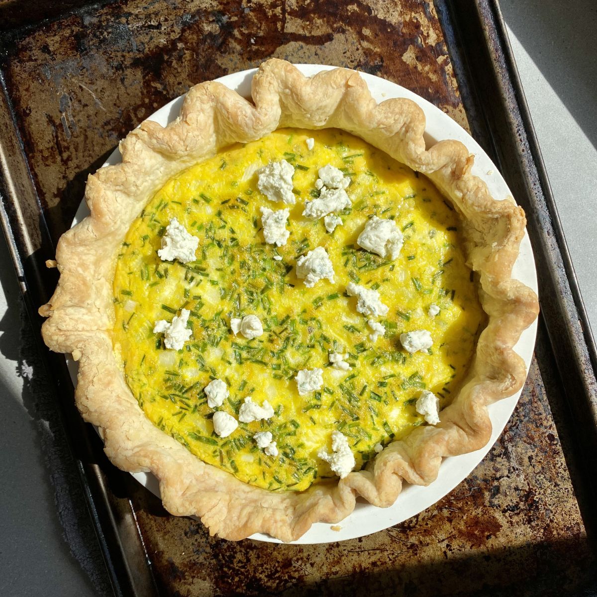 cooked boursin quiche on a baking sheet.