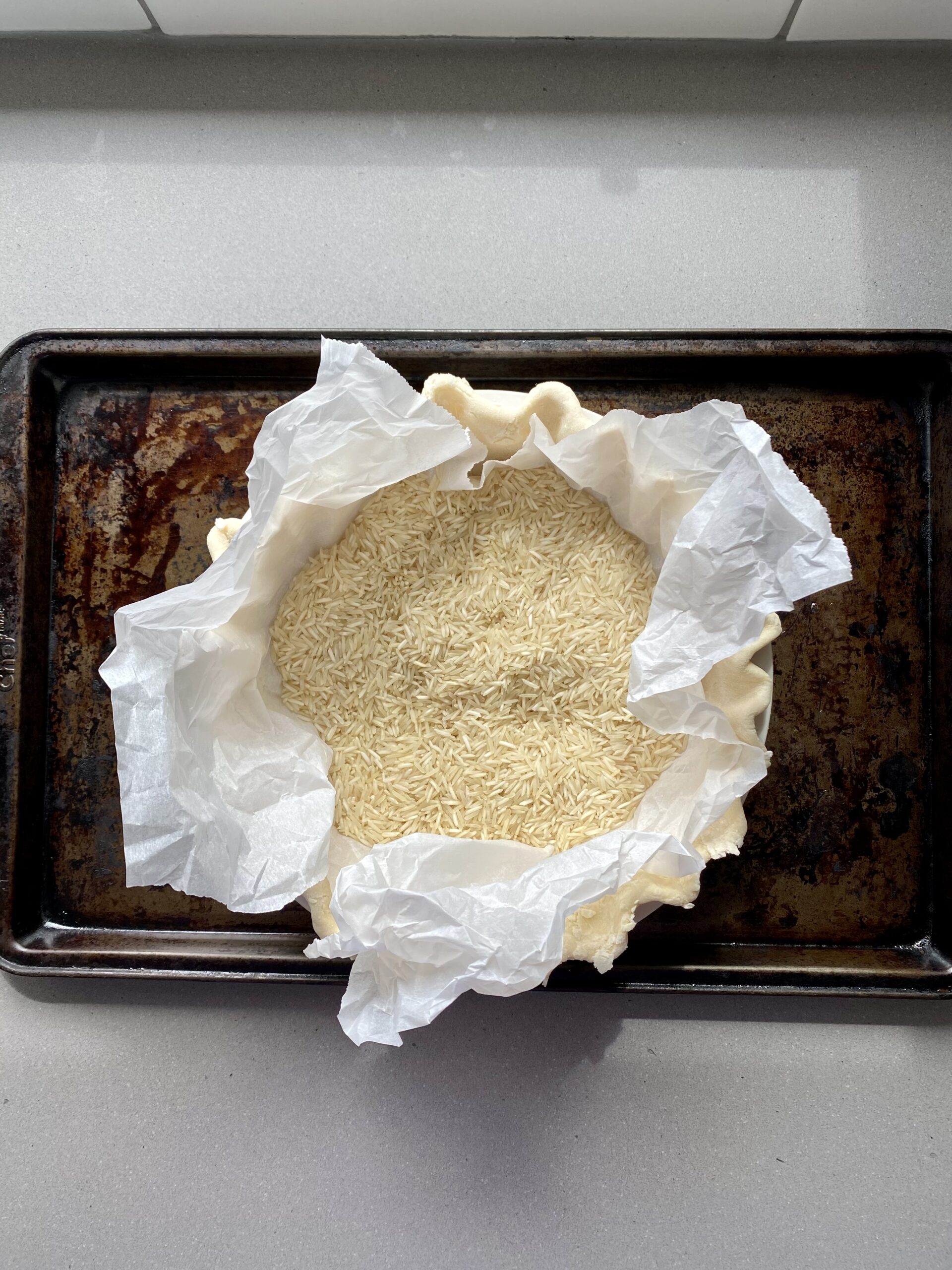 pie dough ready for blind baking, with parchment paper and pie weights.