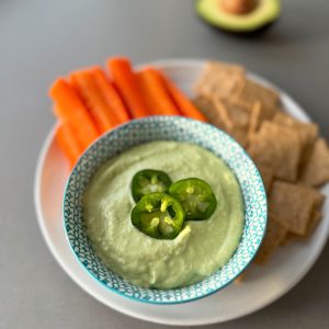 avocado dip in bowl served with veggies and carrots