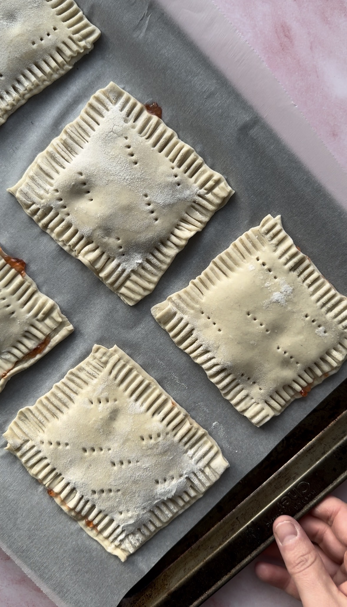 6 pop tarts on a baking sheet ready for baking.