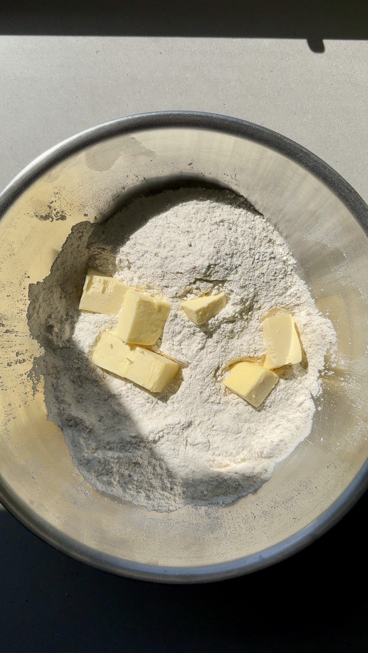 dry ingredients mixed together with cubed butter in a bowl.