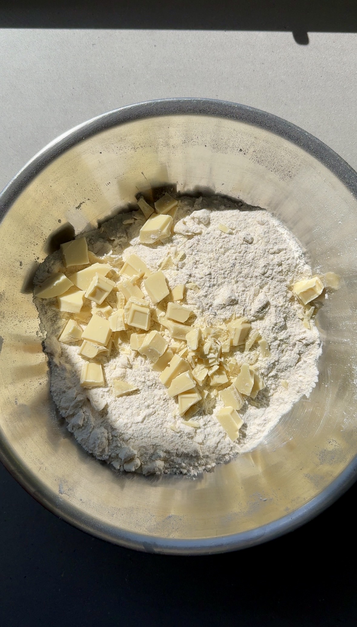 dry ingredients with white chocolate chunks in a bowl.