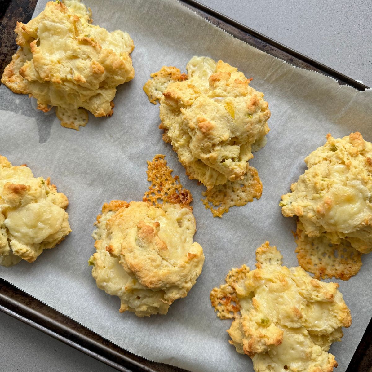 baked cheese drop biscuits on a baking sheet.