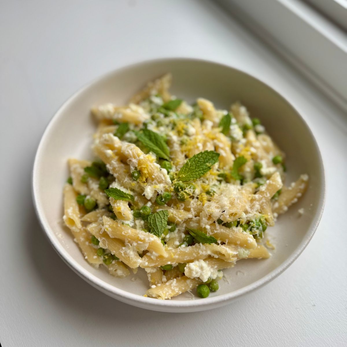 pea ricotta pasta in a white bowl.
