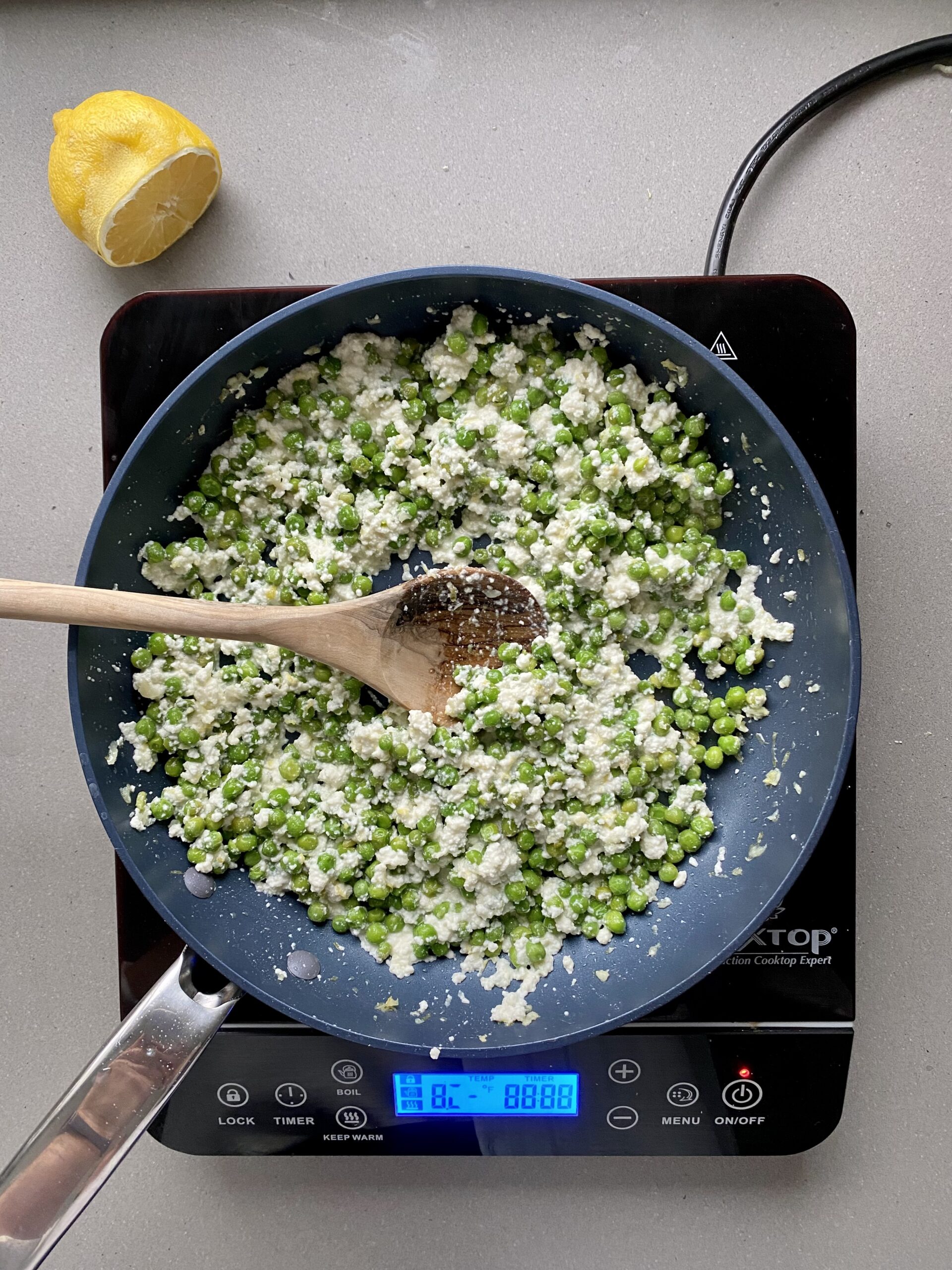 ricotta mixed with peas and lemon zest in a frying pan.